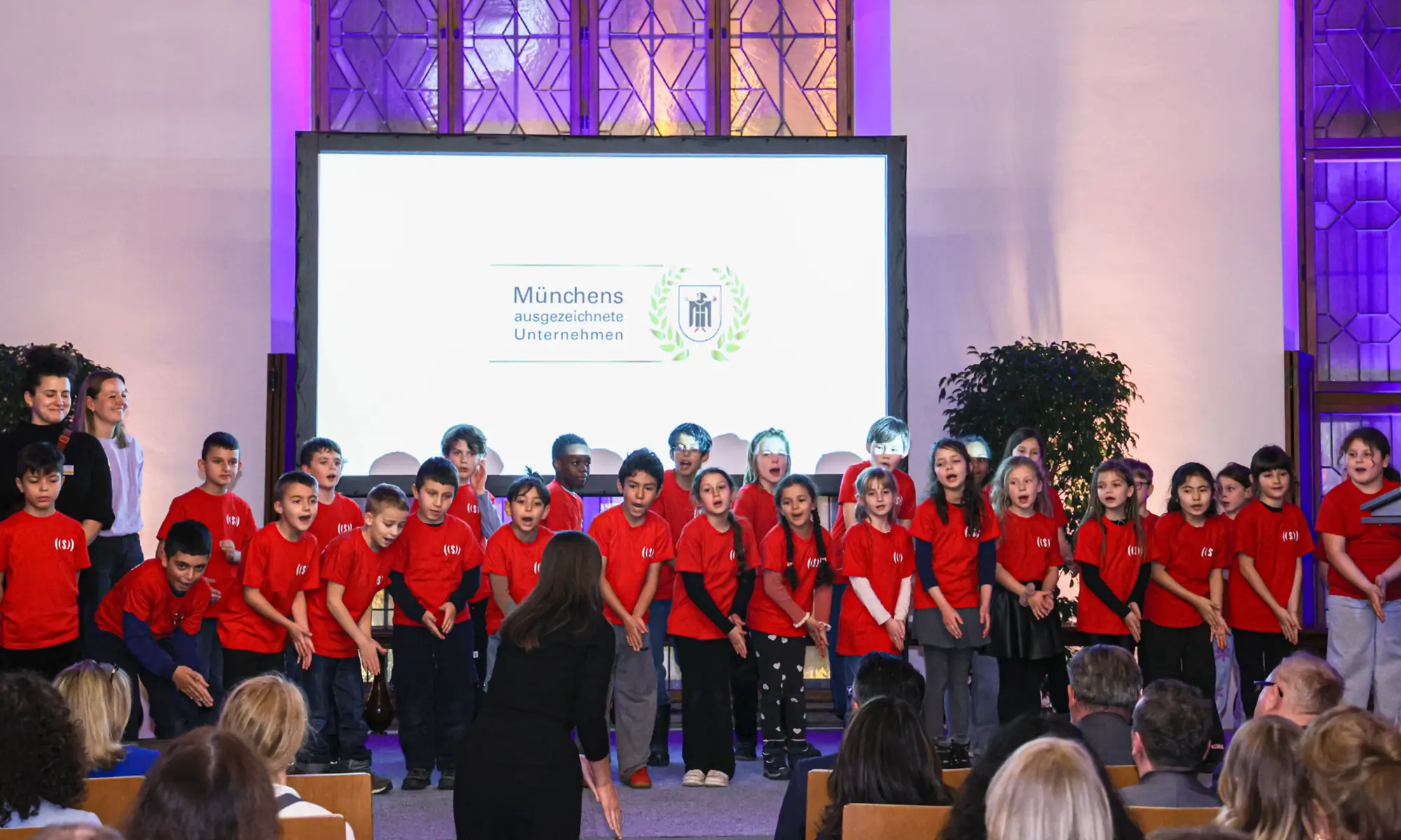 Die Kinder des Superar Chors stehen auf der Bühne und bewegen ihre Hände zur Musik.