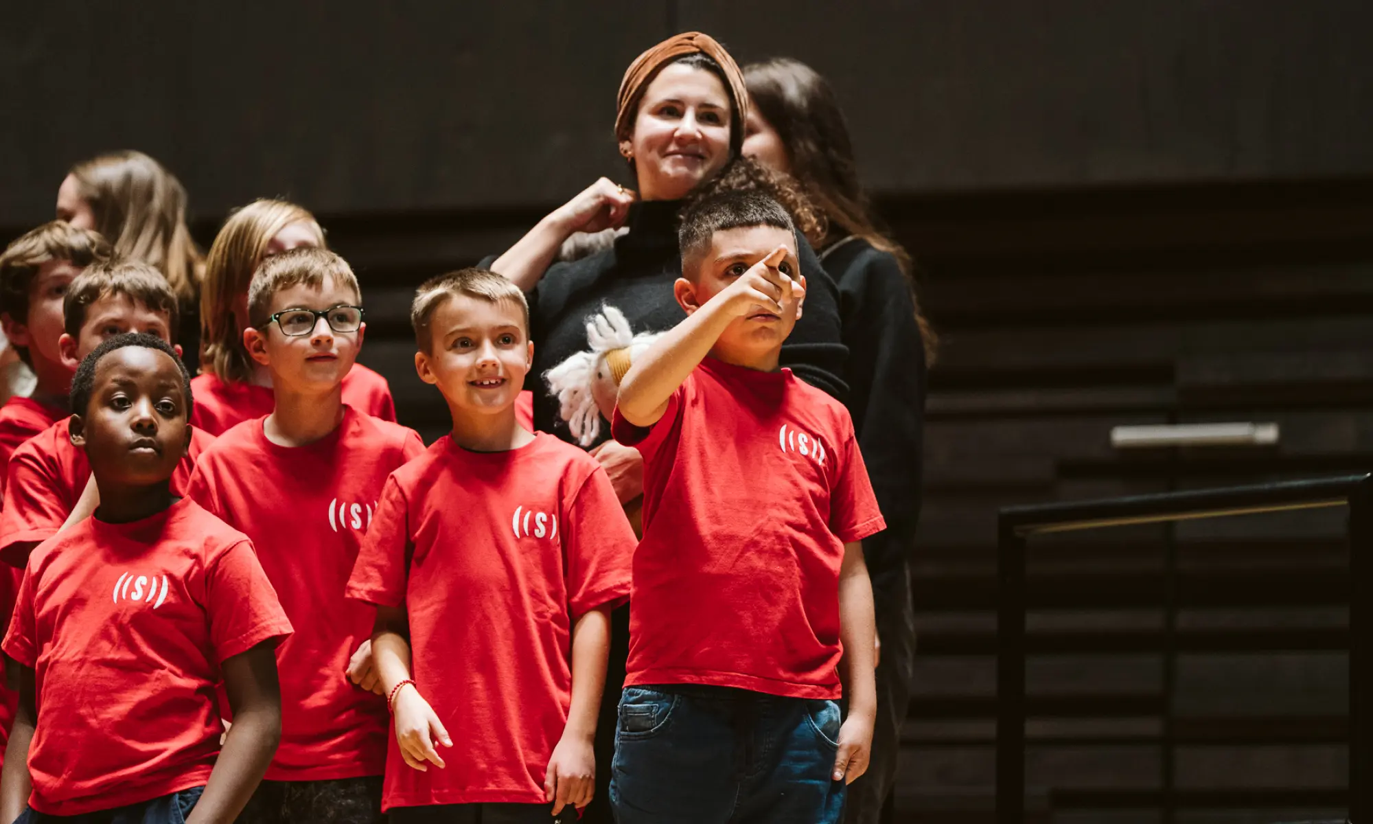 Kinder zeigen auf etwas beim Superar Jahreskonzert 2025